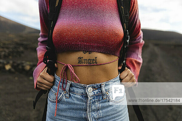Woman with ANGEL word tattoo on stomach