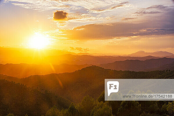 Orange sky over silhouette mountains in Montes De Malaga Natural Park at sunset  Andalucia  Spain  Europe