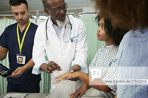 Doctor talking to patient examining recovery at hospital