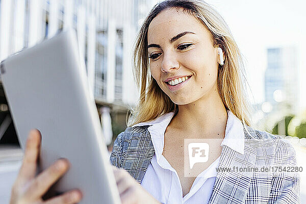 Smiling young businesswoman using tablet PC