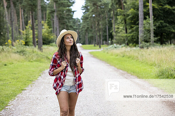 Thoughtful woman walking on road at Cannock Chase