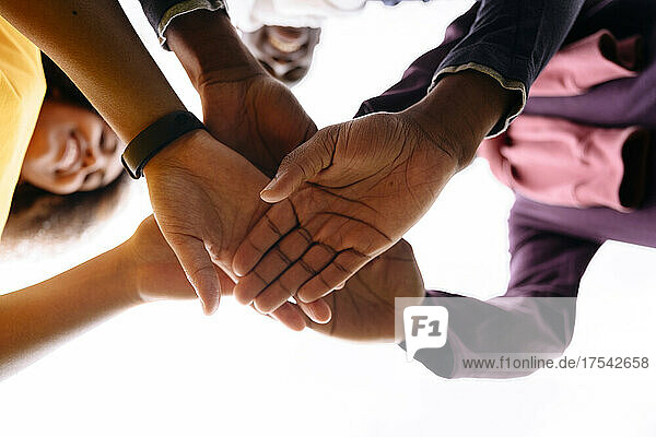 Multiracial young friends stacking hands