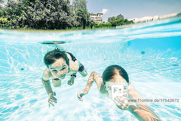 Boys swimming underwater in hotel pool