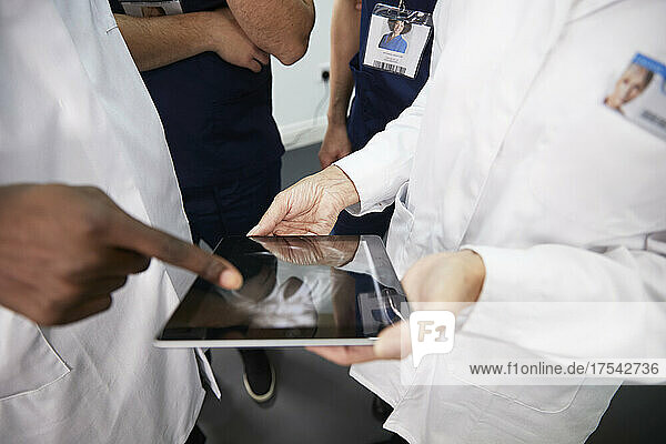 Healthcare workers discussing on tablet PC at hospital