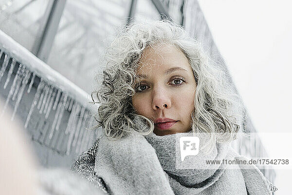 Woman with gray curly hair wrapped in scarf