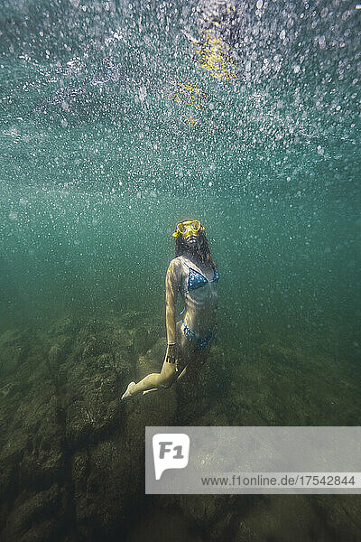 Young woman in bikini swimming undersea