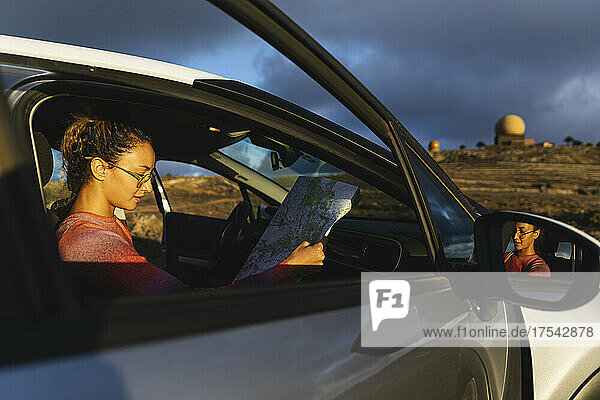 Young woman holding map in car