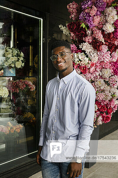 Smiling man standing outside flower shop