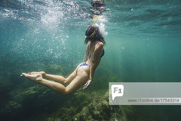 Young woman in bikini swimming in sea
