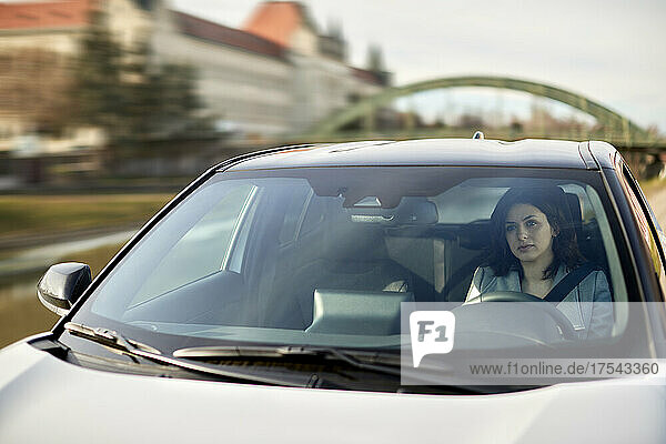 Woman driving electric car on sunny day