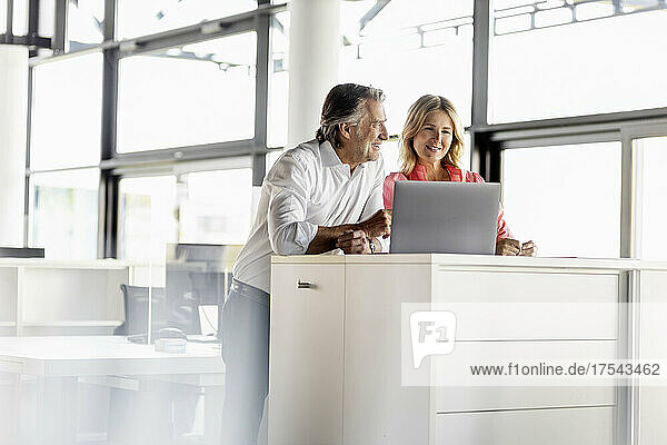 Businesswoman and coworker with laptop at office desk