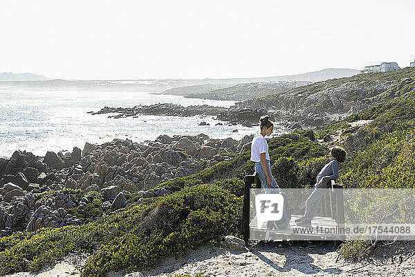 teenage girl and younger brother hiking the De Kelders coastal trail  South Africa