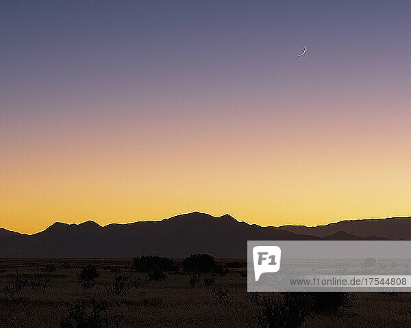 USA  New Mexico  Santa Fe  Crescent moon above Jemez Mountains at sunset