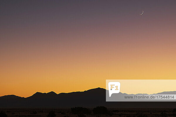 USA  New Mexico  Santa Fe  Crescent moon above Jemez Mountains at sunset