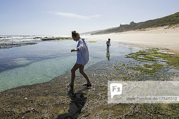 South Africa  Western Cape  Boy (8-9) and girl (16-17) exploring tidal pools in Lekkerwater Nature Reserve