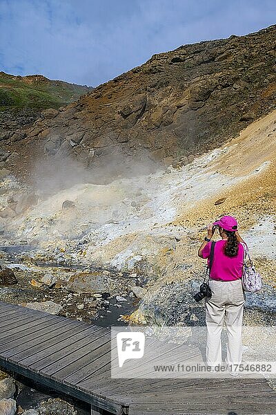 Holzsteg  Touristin im Geothermalgebiet Seltún  mineralische Ablagerungen  Vulkansystem Krysuvik  Island  Europa