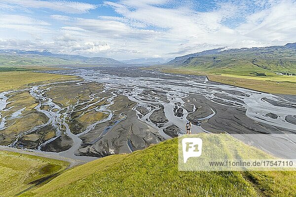 Wanderin auf einem Hügel  Blick über Schwemmland und Flusslandschaft  Fluss mäandert  Dímonarhellir  Suðurland  Island  Europa