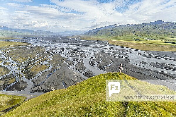Wanderin auf einem Hügel  Blick über Schwemmland und Flusslandschaft  Fluss mäandert  Dímonarhellir  Suðurland  Island  Europa
