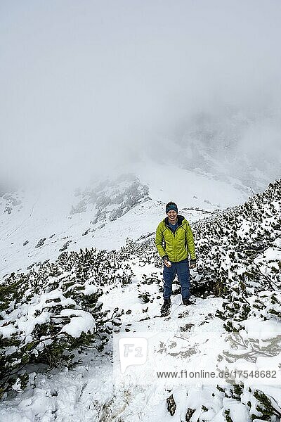 Wanderer auf Wanderweg im Schnee  Wanderung zum Geigelstein im Frühling  Chiemgauer Alpen  Bayern  Deutschland  Europa