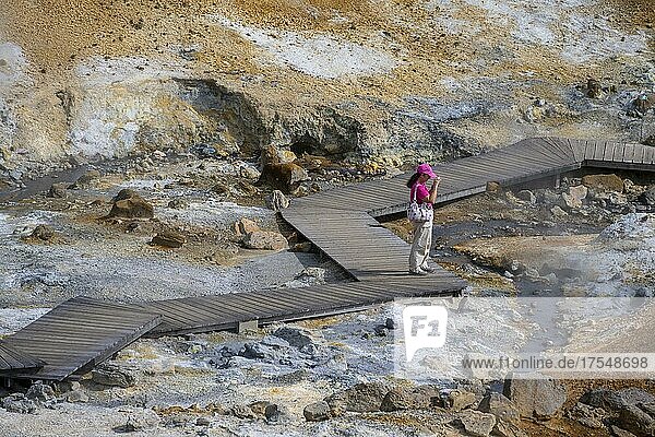Holzsteg  Touristin im Geothermalgebiet Seltún  mineralische Ablagerungen  Vulkansystem Krysuvik  Island  Europa