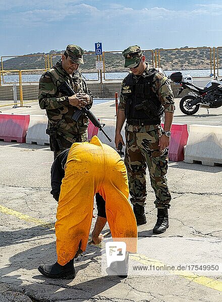Soldaten beobachten einen Handwerker im Hafen von Agios Nikolaos  Kreta  Griechenland  Europa