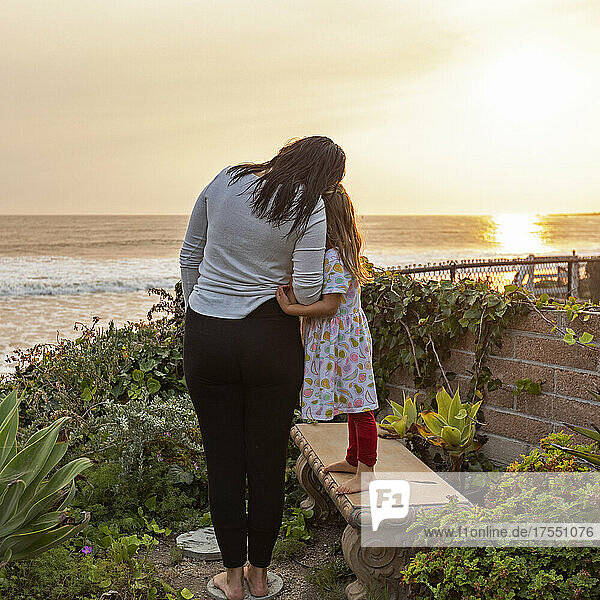 USA  California  Cayucos  Mother and daughter (4-5) on bluff above beach at sunset