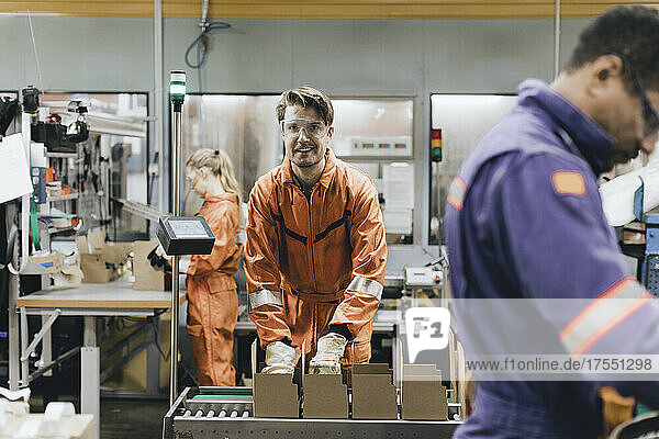 Portrait of smiling male expertise in protective workwear working in industry
