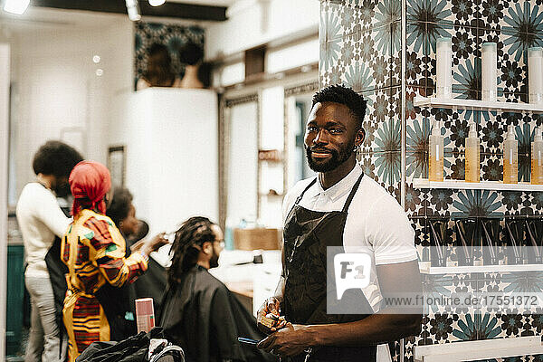 Portrait of male hairdresser standing in barber shop