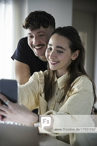 Glückliches Paar nimmt Selfie auf Smartphone zu Hause