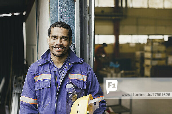 Portrait of confident male worker in protective workwear at factory