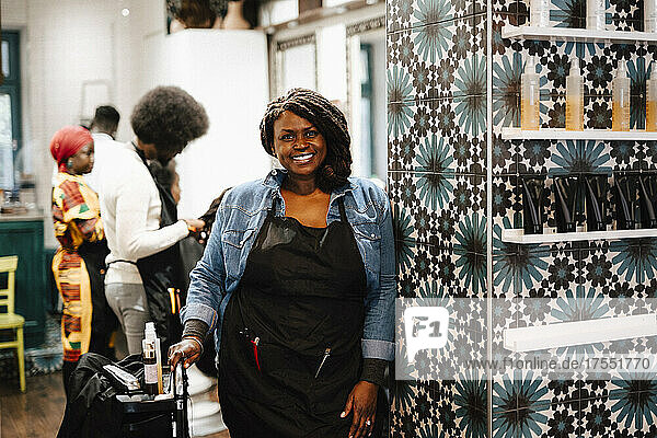 Portrait of smiling mature female hairdresser in barber shop