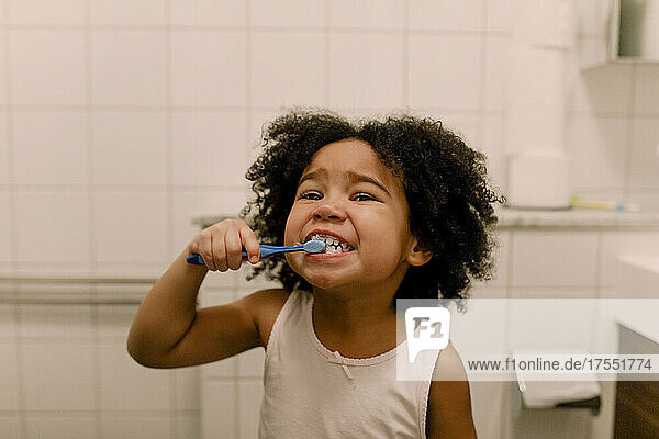 Girl brushing teeth in bathroom