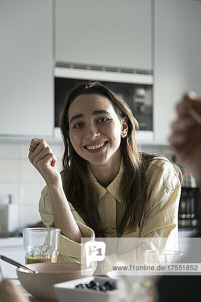Portrait of smiling woman having breakfast at table