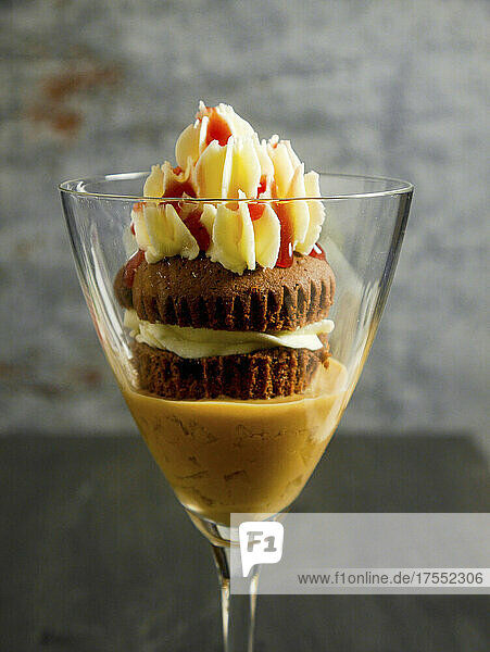 Autumn dessert of a chocolate cupcake with buttercream frosting on caramel apple cream served in a glass
