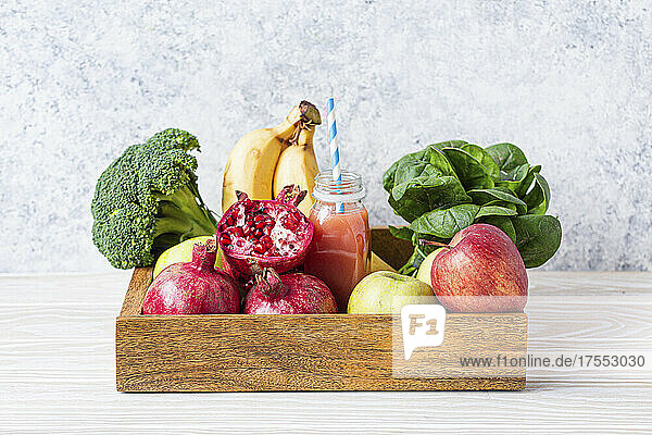 Fruit  greens  vegetables and fresh smoothie in wooden tray