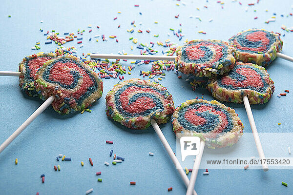 Vegan shortbread biscuits with colourful sugar sprinkles on a stick