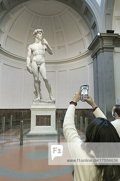 Tourists in a museum  Taking a photo in front of the statue of David by Michelangelo  Accademia gallery  Florence  Italy  Europe