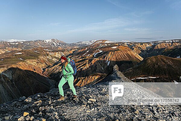 Wanderin auf dem Trekkingweg Laugavegur  Trekkingweg Laugavegur  Dramatische Vulkanlandschaft  bunte Erosionslandschaft mit Bergen  Lavafeld  Landmannalaugar  Fjallabak Naturreservat  Suðurland  Island  Europa