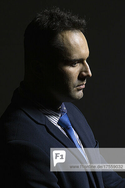 Profil Porträt ernst  gut aussehend Geschäftsmann auf schwarzem Hintergrund