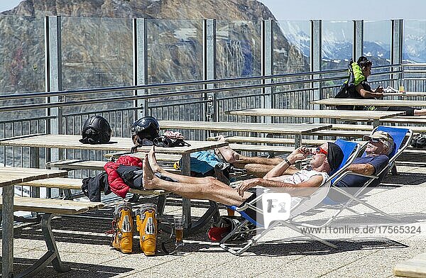 Two skiers sunbathing  terrace of the glacier hut  Hintertux glacier ski area in summer  Tuxeertal  Tyrol