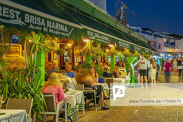 Blick auf Restaurants und Geschäfte mit Blick auf den Strand Playa Blanca in der Abenddämmerung  Playa Blanca  Lanzarote  Kanarische Inseln  Spanien  Atlantik  Europa