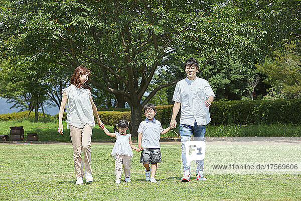 Japanese Family Strolling In The Park
