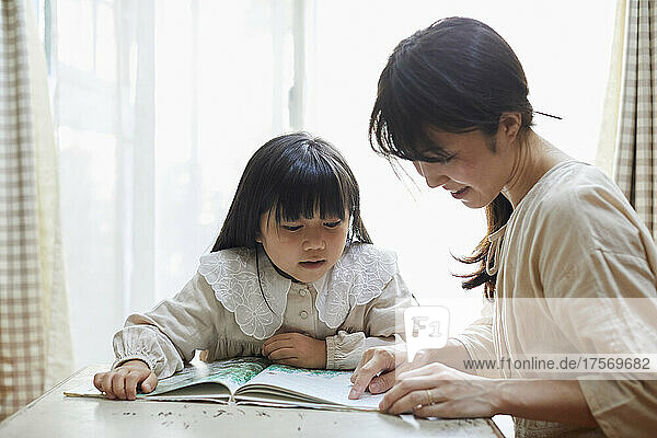 Japanese Parent And Child Reading A Book