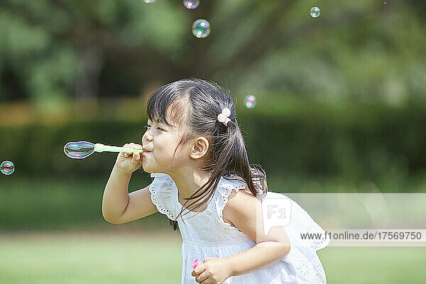 Japanese Girl Playing With Soap Bubbles