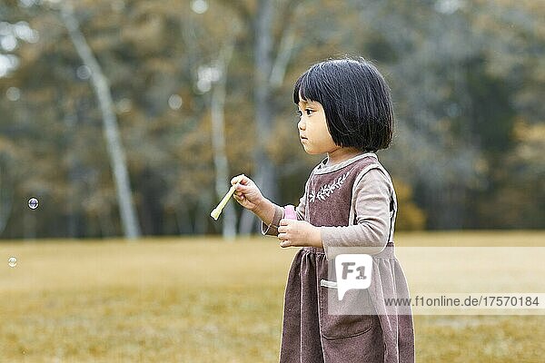 Japanese Girl Playing With Soap Bubbles