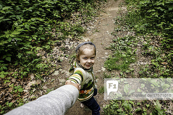 Girl pulling mom in the woods on a hike