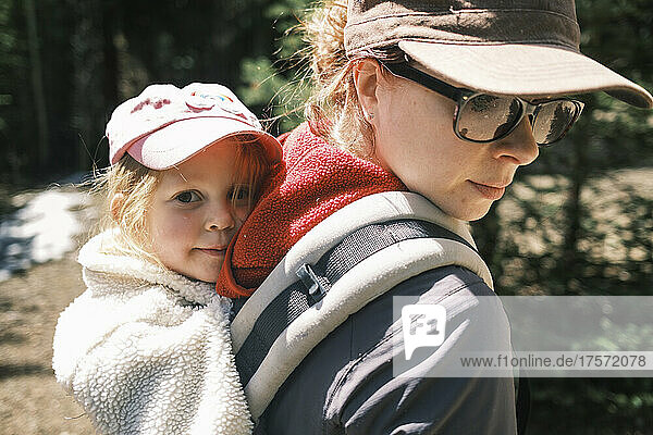 Mother carrying her daughter while on a hike in Colorado