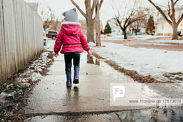 Young girl goes on walk through neighborhood during winter