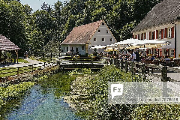 Wimsen mill on the river course of the river Ach  Bannmühle  on the right garden restaurant with sunshades  Gasthof Friedrichshöhle  in front man with backpack  people  Hayingen-Wimsen  Baden-Württemberg  Germany  Europe