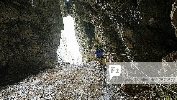 Junger Mann klettert im Klettersteig in einem Felsloch  Klettersteig Brudertunnel  Karwendelgebirge  Alpenpark Karwendel  Tirol  Österreich  Europa
